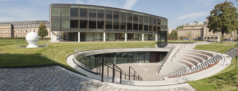 Der Landtag von Baden-Württemberg ist ein modernes, flaches Parlamentsgebäude mit großen Glasfassaden inmitten einer Grünanlage in Stuttgart